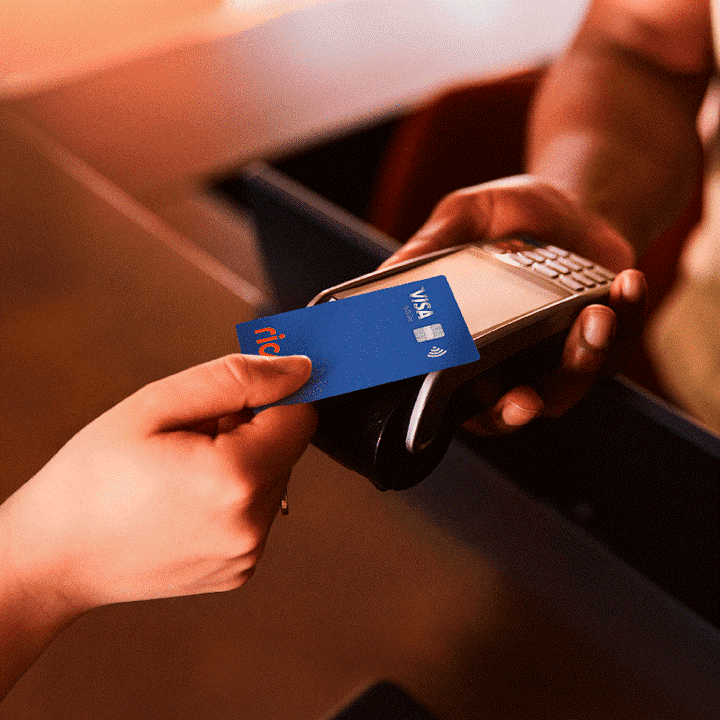 Cartão de crédito Rico Visa sendo utilizado por aproximação em maquininha